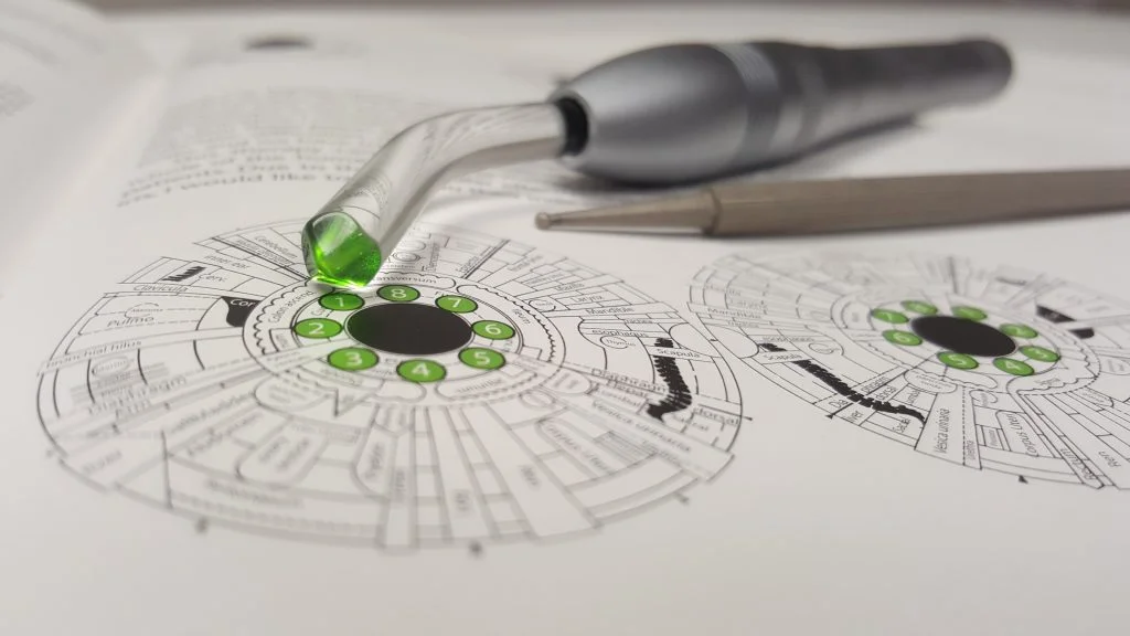 The Colorpuncture Light tool sitting on top of an OGT therapy diagram