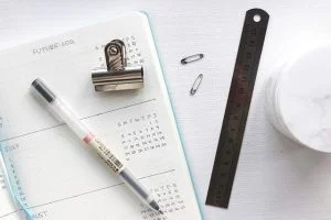 a Calendar book with a pen, clippy, and ruler