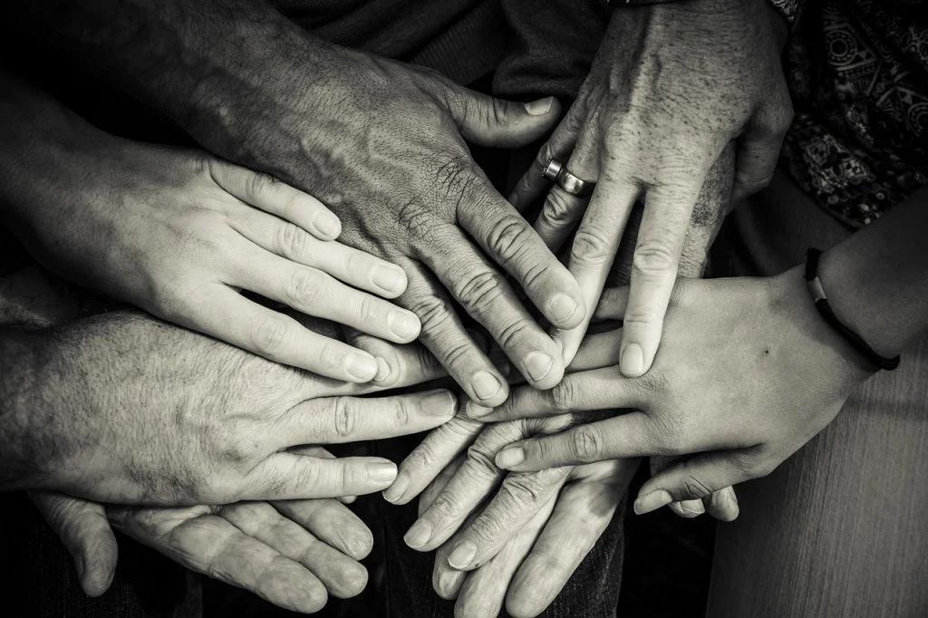 Multiple hands touching in other in a circle.